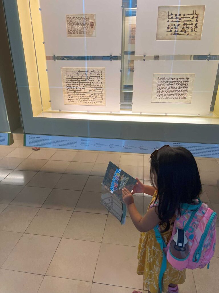 Toddler using the Museum Quest booklet at Islamic Arts Museum Malaysia.