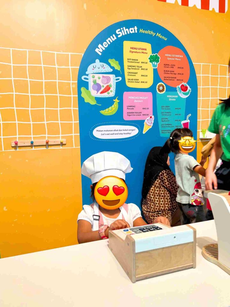 Kids play with an interactive exhibit at Bank Negara Malaysia Museum, one of the best free things to do in Kuala Lumpur with kids.